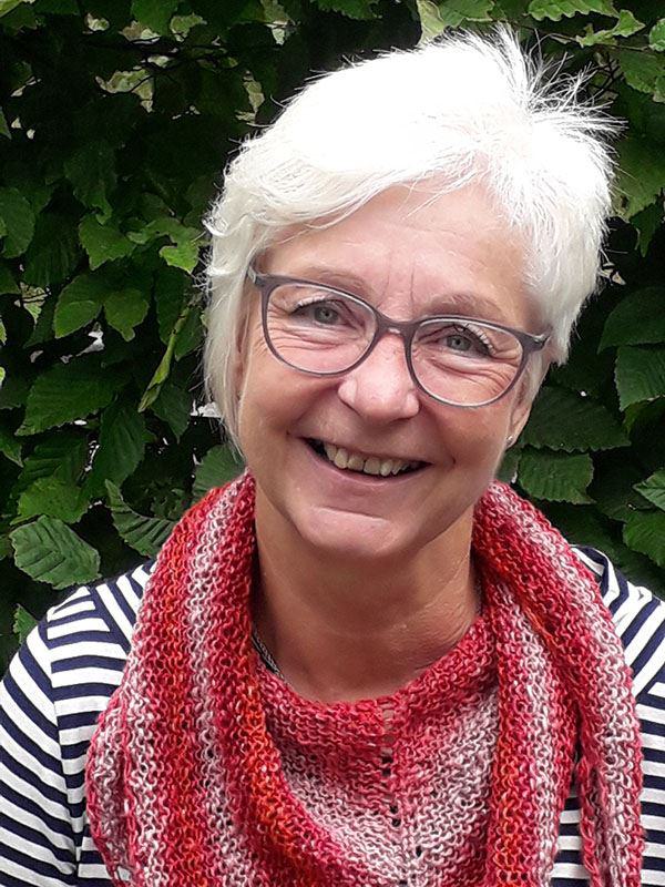 Frau mit Brille und rotem Schal lächelt